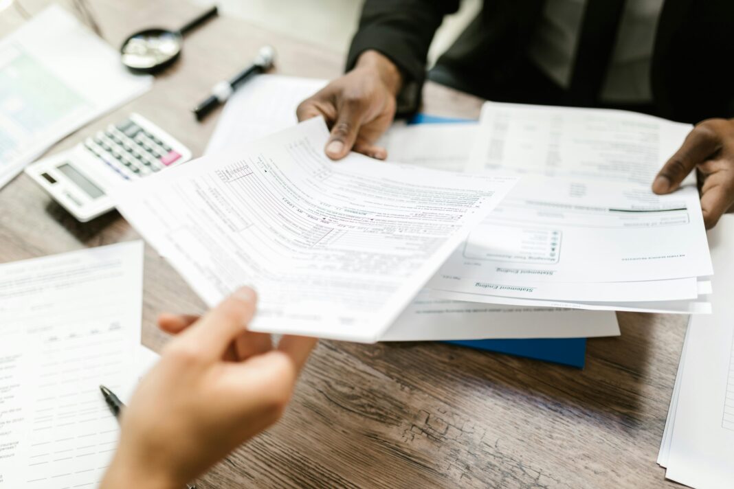 Professionals review documents, possibly related to BlackBuck IRDAI insurance approval process.